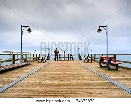 Man On Mole, Autumn Misty Morning. Tourist At Handrail.