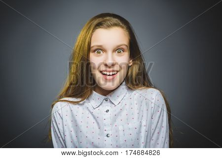 wondering girl. Closeup Portrait of handsome teen in casual shirt on grey background.