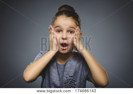 wondering girl. Closeup Portrait of handsome child in casual shirt on grey background.
