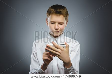 Portrait of offense boy with mobile or cell phone. Negative human emotion.