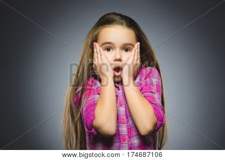 wondering girl. Closeup Portrait of handsome teen in casual shirt on grey background.
