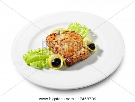 Fisch Steak serviert mit Salat Blätter, Zitrone und Oliven. Isoliert auf weißem Hintergrund