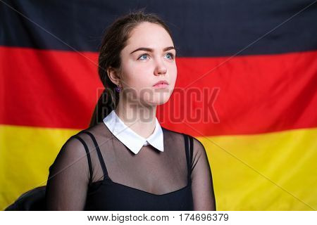 Portrait of a beautiful calm brunette girl in the background of the German flag