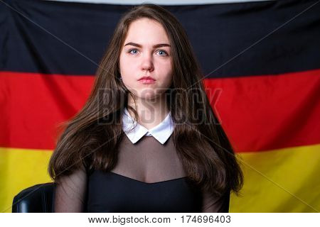 Portrait of a beautiful calm brunette girl in the background of the German flag