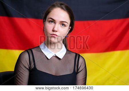 Portrait of a beautiful calm brunette girl in the background of the German flag
