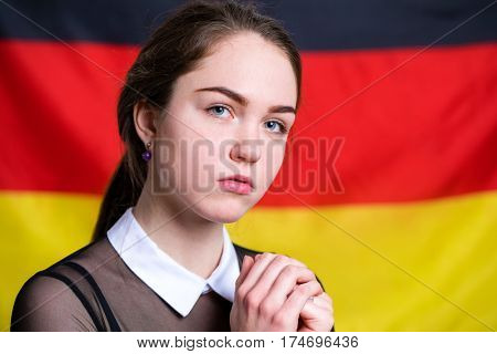 Portrait of a beautiful calm brunette girl in the background of the German flag