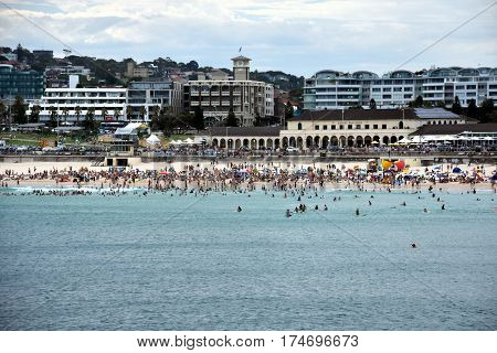 Sydney Australia - Feb 5 2017. People relaxing swimming and sun bathing on Bondi beach. Bondi Pavilion in the background. Bondi beach is one of the most famous tourist sites in Australia.