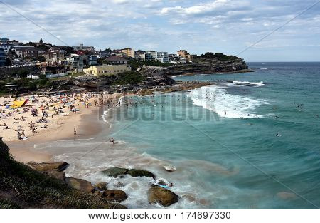 People relaxing swimming and sun bathing on Tamarama beach.