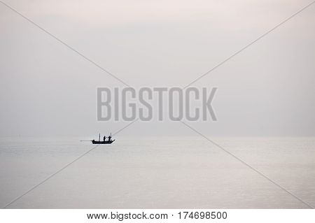 silhouette minimalist image of single fishery boat float on calm sea with copy space