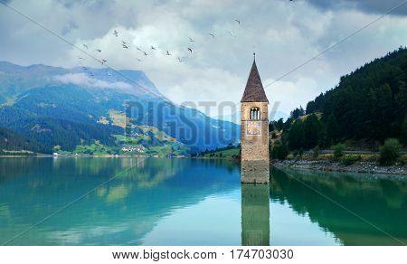 Beautiful view of the lake Resia. Famous tower in the water. Alps, Italy, Europe.