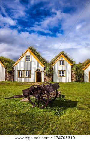 Facade of the farmhouse and ancient rural  wheelbarrow. The concept of the historical and cultural tourism. Ethnographic Museum Glaumbaer, Iceland