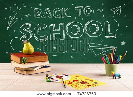 Back to school concepty with writing on blackboard and desk, apple, books, items