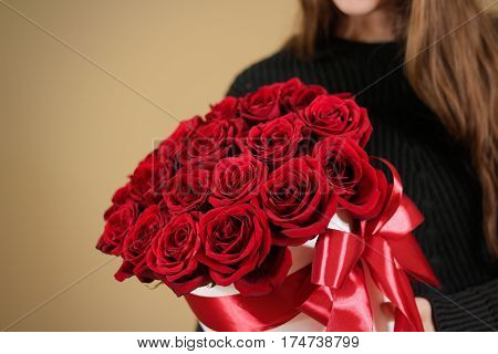 Girl In Black Jacket Holding In Hand Rich Gift Bouquet Of 21 Red Roses. Composition Of Flowers In A