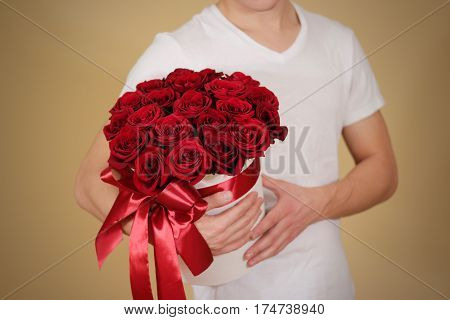 Man In White T Shirt Holding In Hand Rich Gift Bouquet Of 21 Red Roses. Composition Of Flowers In A