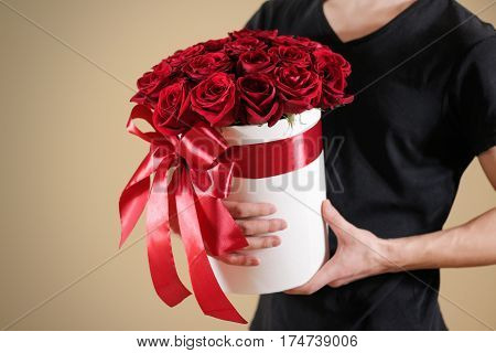Man In Black T Shirt Holding In Hand Rich Gift Bouquet Of 21 Red Roses. Composition Of Flowers In A
