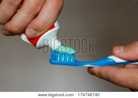 squeezes toothpaste on the brush, close up