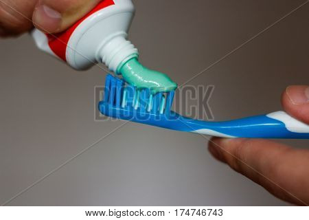 squeezes toothpaste on the brush, close up