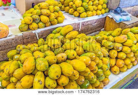 The heaps of yellow papaya on the counter of the stall in Fose Market Colombo Sri Lanka.