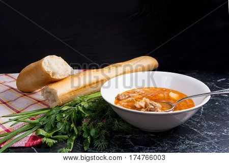 Vegetables And Meat In Red Beetroot Soup Or Borsch In White Plate With Metal Spoon In It On Dark Mar