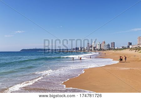 People On Morning Visit To Beach Against Blue Sky