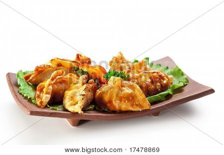Cucina giapponese - carne di maiale (o pesce) gnocchi (gyoza). Guarnito su foglia di insalata con pepe e Fres