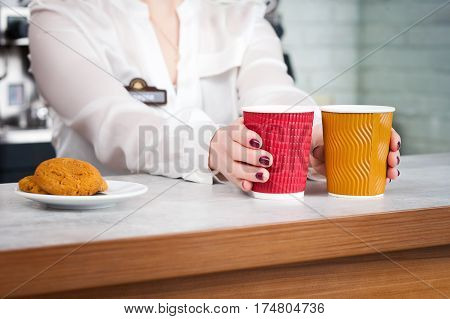 female barista and two customers in a cafe