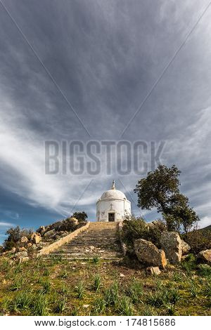 Wispy clouds above the steps leading to a large white domed mausoleum at Palasca in the Balagne region of Corsica