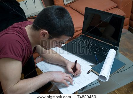 Photographing Danila Mazić in a tight red shirt and black pants while drawing construction plans, Novi Sad, Serbia