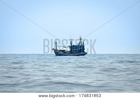 blue Fishing trawler on the ocean water alone
