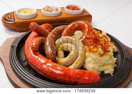 Delicious sausages with different sauces and potatoes.