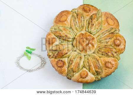 Creative homemade cake of yeast dough with stuffed of cottage cheese. The original cake in shape of flower and card for your text. Festive dessert for Mother's Day birthday anniversary. Top view