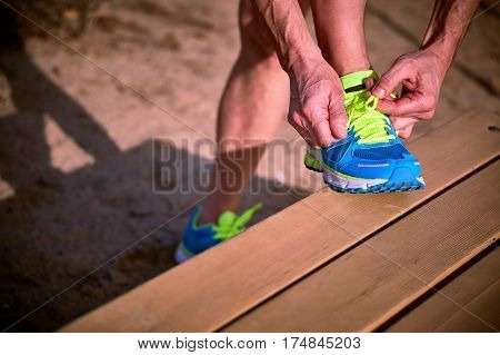Tying shoelaces on sneakers during class outdoor sports.
