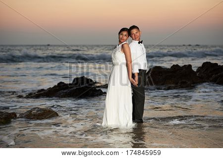 Groom And Bride Stand In Sea Water