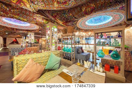 MOSCOW - AUGUST 2014: Interior Chaihana Lounge Eastern restaurant in a traditional style. The main hall with colorful fabric ceiling with ethnic patterns. Rack with glassware