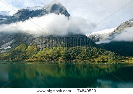 detail of a fjord in norway on a cloudy sky