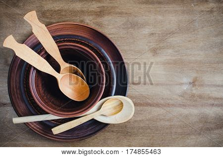 Rustic Kitchen Utensils: the Ceramic Plates and Wooden Cutlery on Wooden Background. Home Wares. Kitchen Decor in Rustic Style. View From Above With Copy Space.