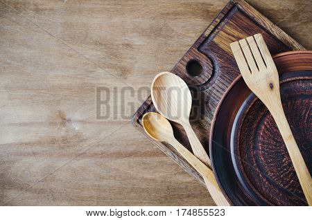 Rustic Kitchen Utensils: the Ceramic Plates and Wooden Cutlery on Wooden Background. Home Wares. Kitchen Decor in Rustic Style. View From Above With Copy Space.