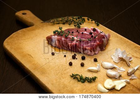 Beef steak. Raw marble beef on a cutting board. On a black background for text design or restaurant menus. Food background. Horizontal photo.