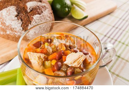 Mexican soup with chicken celery lime bread and vegetables close-up