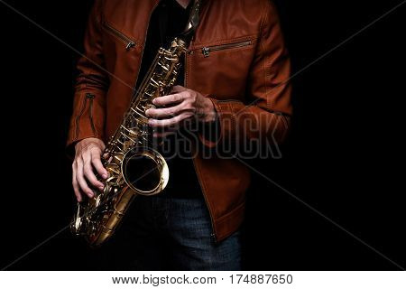 male jazz saxophone player on the stage with brown leather jacket