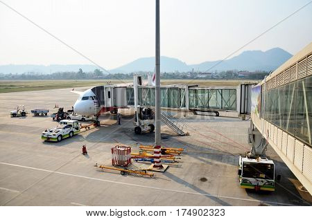 Laotian People Loading Baggage To Store Room Of Plane For Flight At Louangphrabang Airport