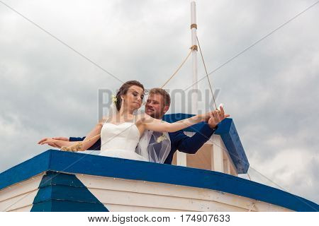 Wedding couple on small boat. The bride and groom on the ship.