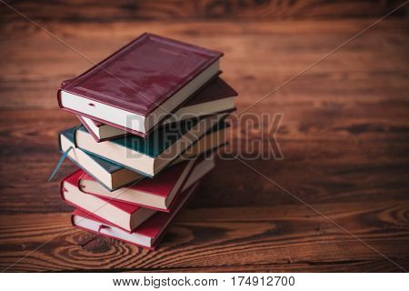 pile of dusty old books on a wooden background with copy space