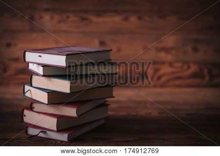 dirty unread old books waiting for a reader on wooden background