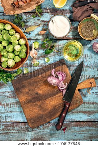 Old cutting board with ingredients for cooking tasty and healthy food on thw wooden table top view. Food background. Healthy food