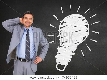 Digital composite image of businessman standing next to light blub against black background