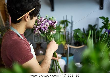 Man with bunch of flowers enjoying its smell