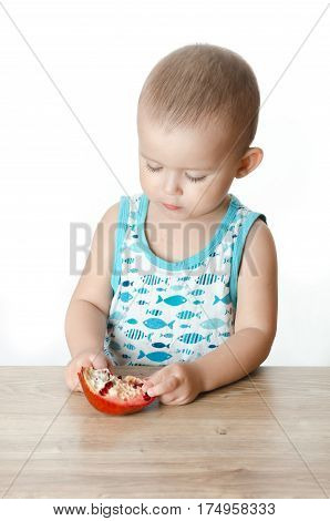 Baby eats a pomegranate ripe and juicy very tasty and joyfully