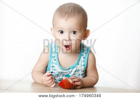 Baby eats a pomegranate ripe and juicy very tasty and joyfully