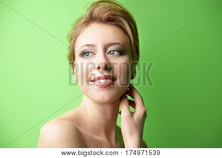Young woman with trendy hairstyle on green background